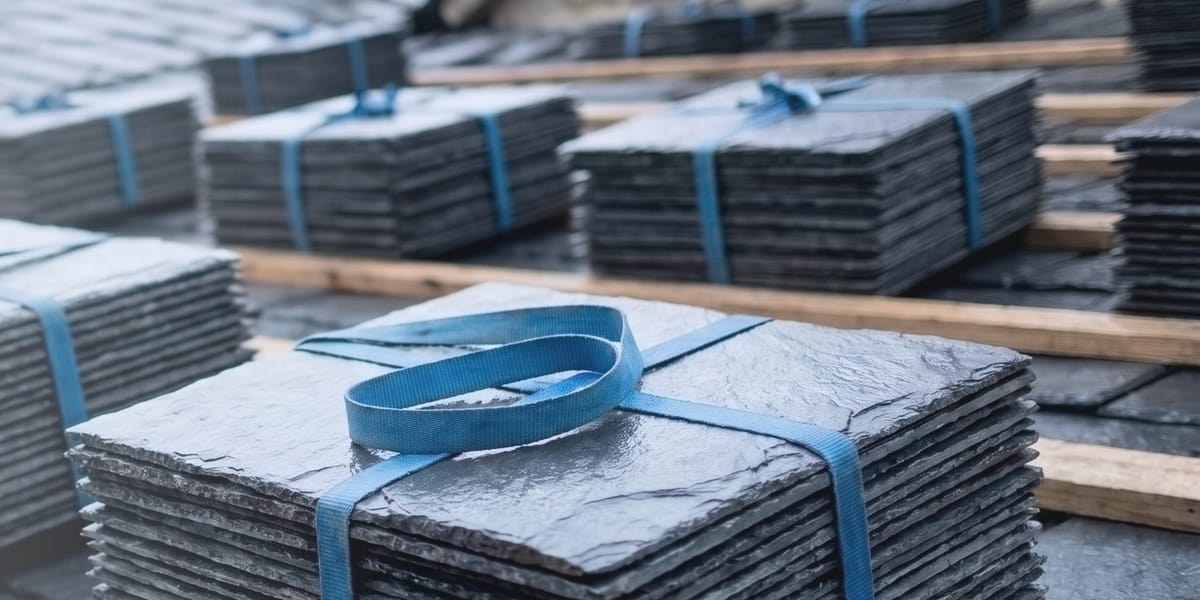 Gestapelte Schieferplatten mit blauem Spanngurt